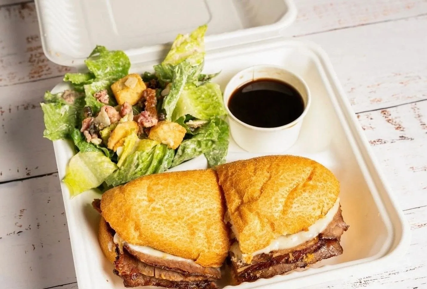 The Baron of Beef Dip, sliced roast beef with crispy onions and horseradish aioli on a garlic-toasted bun
